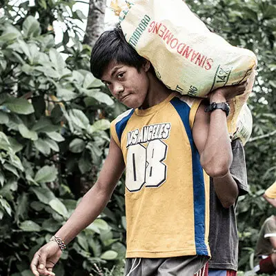 Filipino boy carrying a sack