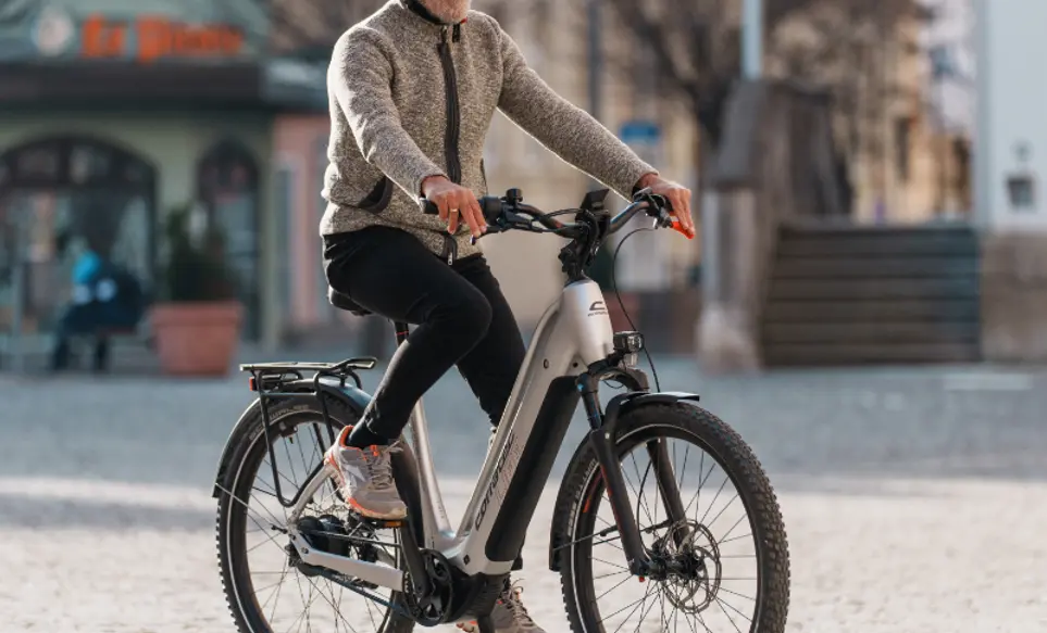 Mann fährt auf corratec E-Power MTC 120 durch die Rosenheimer Innenstadt