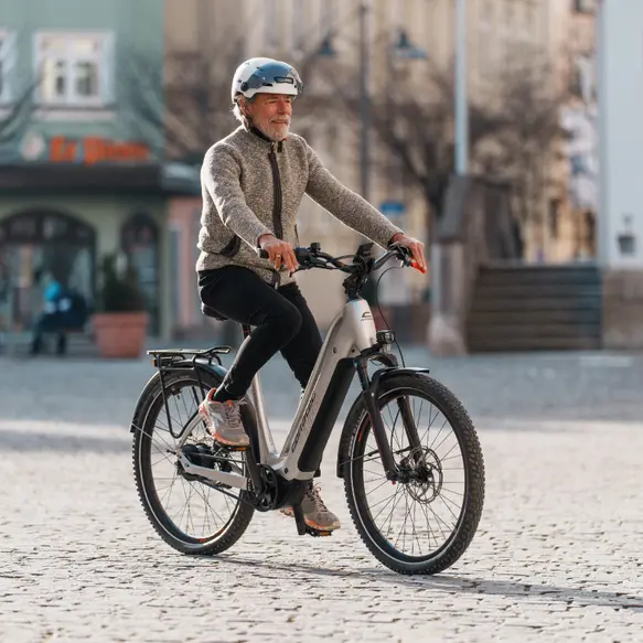 Mann fährt auf corratec E-Power MTC 120 durch die Rosenheimer Innenstadt