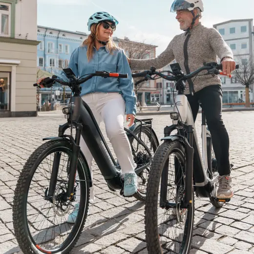 Frau und Mann stehen mit ihren E-Bikes in der Rosenheimer Innenstadt
