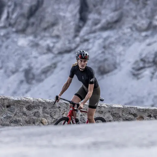 Sportliche Frau auf rotem corratec Rennrad CCT Evo fährt eine Passstraße in den Alpen
