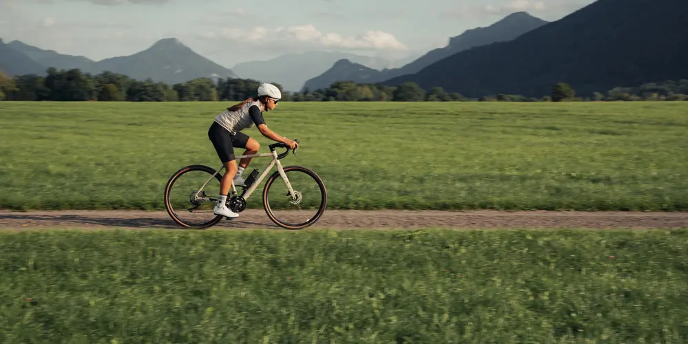 Fahrer auf einem corratec Gravelbike auf Schotterweg